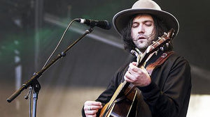 Conor Oberst performing live on stage with a guitar